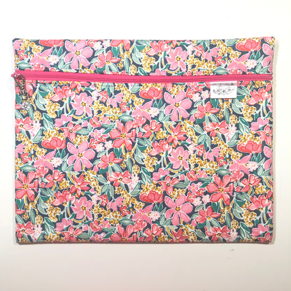 Floral-patterned bag with a pink zipper on a white background